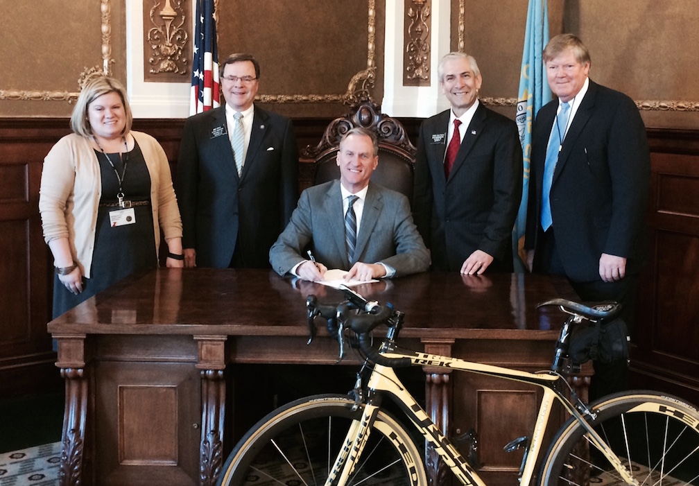 Governor Dennis Daugaard (center) signs HB 1030 into law, March 11, 2015. Attending the signing ceremony are (L to R) Megan Myers, government relations director, American Heart Association; Sen. Mike Vehle (R-20/Mitchell); Rep. Fred Deutsch (R-4/Florence); and Dean Krogman, lobbyist.