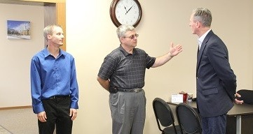 Walter Schoenfish (center) gives Governor Dennis Daugaard (right) a tour of Schoenfish & Co., Inc.'s Parkston office, while Rep. Kyle Schoenfish (left) looks on adoringly. Photo from City of Parkston, 2014.08.27.