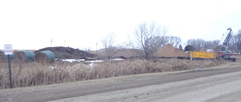 Gravel, dirt, and equipment in staging area where houses have been cleared west of Park Street, Lake Norden, South Dakota, 2017.12.15.