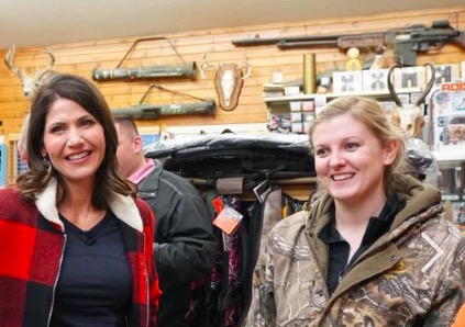 Kristi Noem on the campaign trail at Kones Korner, posing happily amidst one of the major factors in suicide, from Noem campaign Facebook, 2018.02.19.