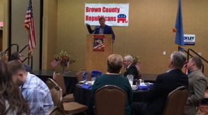 Neal Tapio waves his arms angrily at turncoat GOP leaders in front of GOP leaders. Screen cap from Brown County Republicans Lincoln Day Dinner video, 2018.04.05.