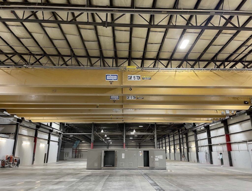 Contrx overhead bridge cranes, a Wisconsin product! Batteries and 130-foot-wide shop sold separately. Photo by The Branford Group, retrieved online 2021.11.07.