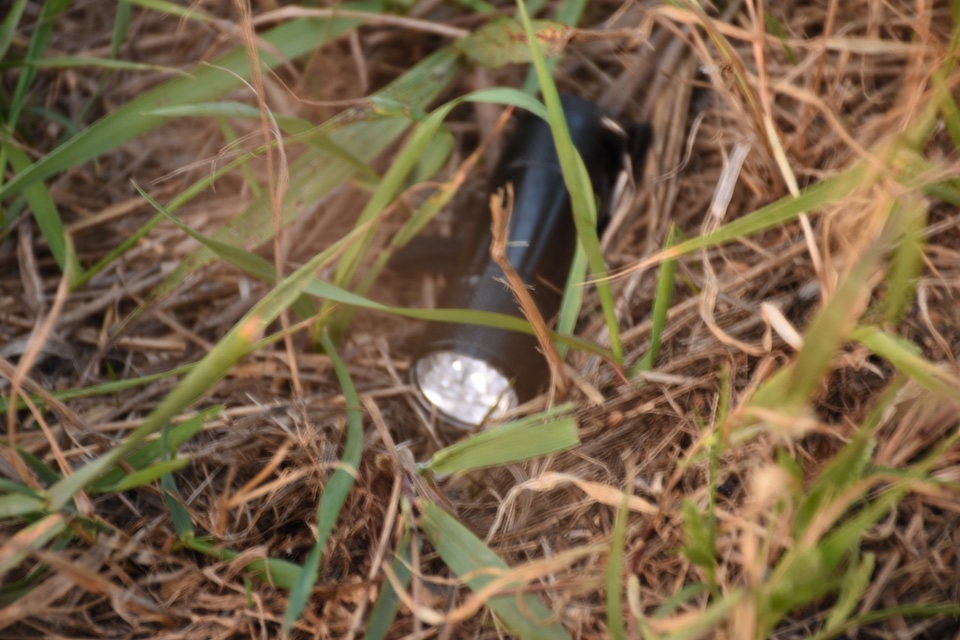 Document 437_0640: crime scene photo of Boever flashlight at edge of Hwy 14, 2020.09.13. Retrieved from Senate Court of Impeachment documents 2022.06.03.