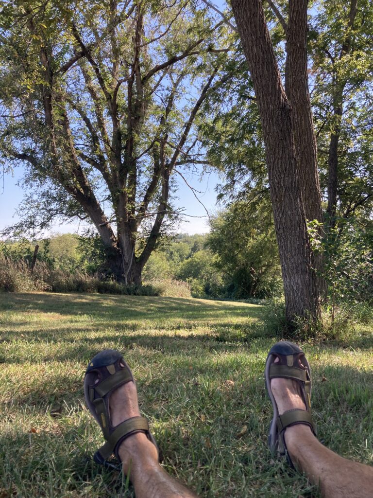 Beth wore me out! Time for a shade break on Cedar Island Road, a nice strip iof gravel not yet swallowed up and blacktopped by the Omaha–Bellevue metro.
