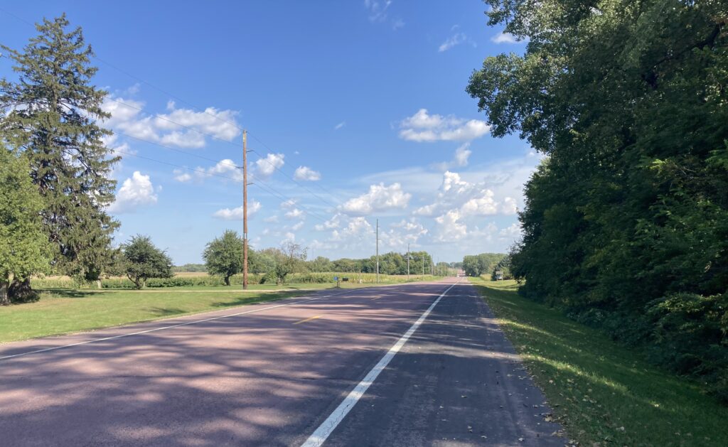 Shady spot along the road, west of Madelia, Minnesota. It was 90+ degrees in southern Minnesota Tuesday, a dozen degrees warmer than usual in mid-September. Even those few seconds of shade provide a welcome respite from the heat. Plant more trees!